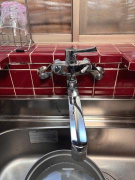 工事前　針金で固定してある吐水パイプの他に、左の止水栓も欠けています。お湯や水の量を調整しようと頻繁に使用しておられたそうです。